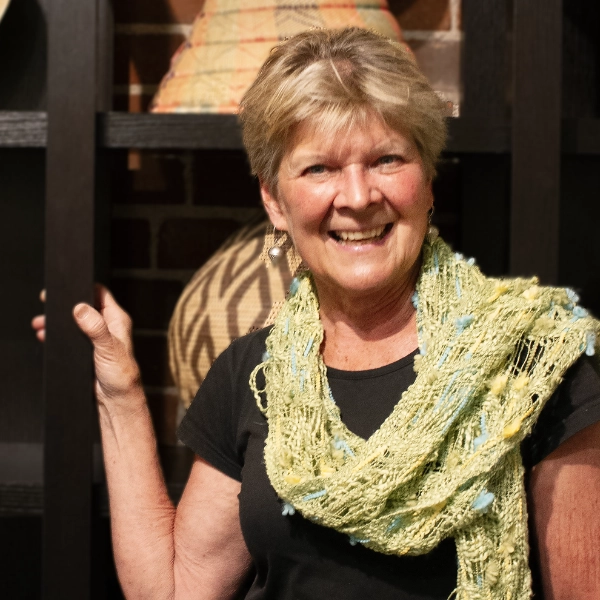 Lynette McGowan-person-smiling-outside-wearing-a-scarf person smiling, standing outside, wearing a scarf