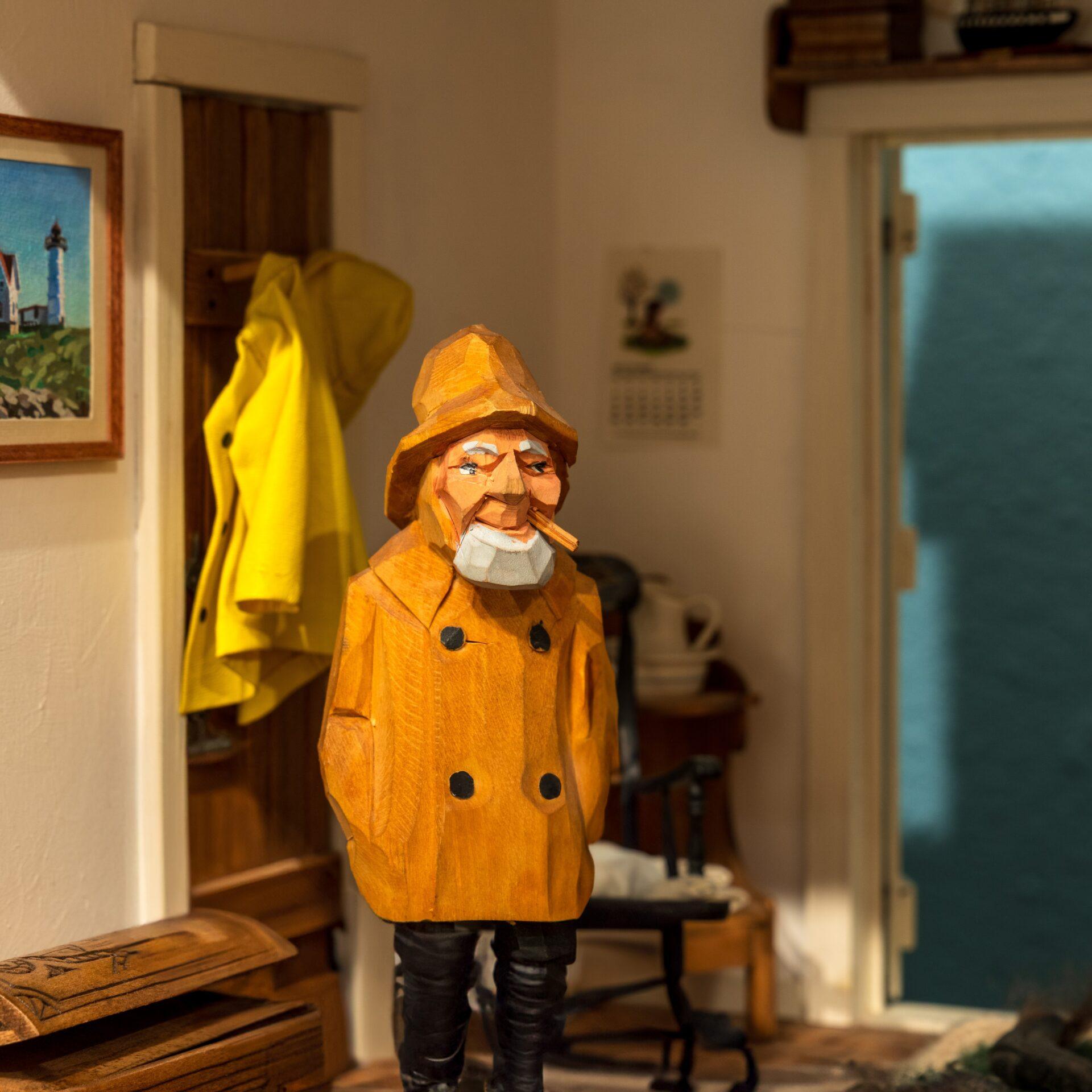 Miniature seafarer in a bright yellow coat in a cozy living room